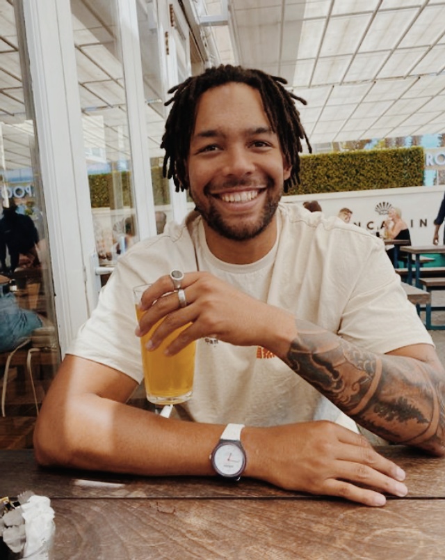 Tony de zorzi sitting in an open restaurant and drinking coffee and smiling